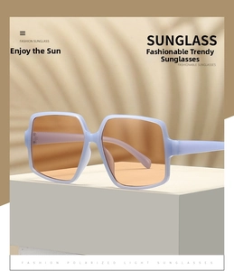 Detail of oversized irregular sunglasses with purple frames and polarized amber lenses