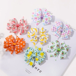 Detail of diverse kids bow hair clips with vibrant tropical fruit and floral prints