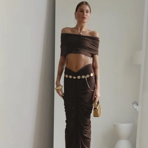 Detailed close-up of dark brown two-piece set with elegant gold coin waist chain accessory