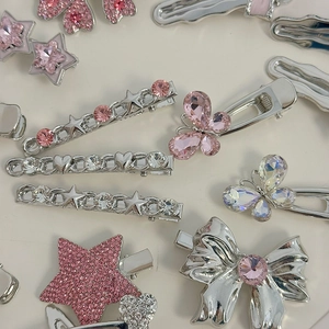 Detailed flat lay of silver hair clip set with pink rhinestones and butterfly designs