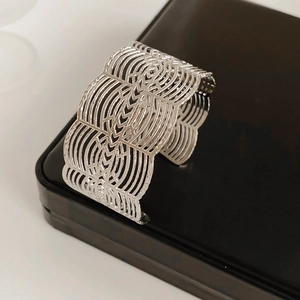Détail du bracelet manchette ajouré argenté avec motifs géométriques découpés au laser