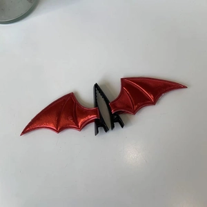 Pair of red and black bat wing hair clips for Halloween with glossy faux leather texture