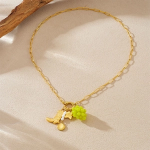 Collana a graffetta dorata con ciondoli a uva, stella, conchiglia e stivale su beige