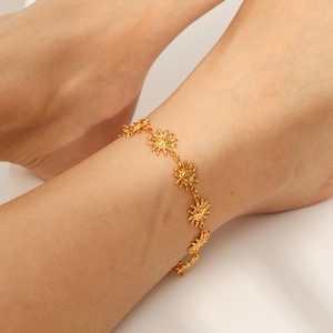 18K gold plated stainless steel sun anklet on model's ankle with white fabric background