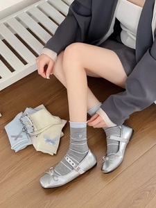 Détail de chaussettes grises rayées avec broderie cœur bleu et nœuds décoratifs élégants