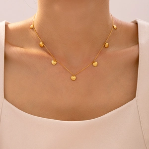 Collana in acciaio al titanio dorato con piccoli ciondoli a conchiglia barocca su modella