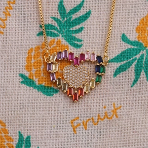 Detail of gold heart pendant with multi-colored crystals and small diamonds