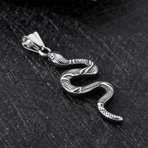 Macro shot of silver stainless steel snake pendant with detailed scales on black background