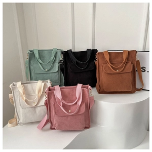 Corduroy tote bags in five pastel colors arranged on a minimalist white display stand