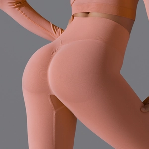 Detail of high waisted coral pink yoga pants with seamless scrunch butt lifting texture