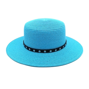 Détail du tressage du chapeau de paille bleu avec bande en cuir à rivets argentés