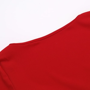 Gros plan de l'encolure ronde avec coutures précises sur une robe rouge à manches longues