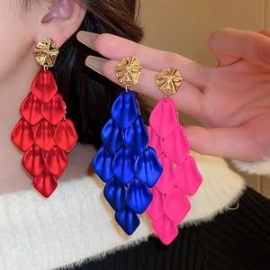 Detailed close-up of colorful layered acrylic petal earrings in red, blue, and pink