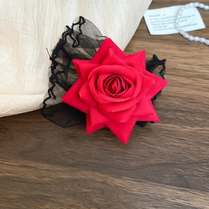 Vue détaillée d'un bracelet en rose de satin rouge et dentelle noire sur bois sombre