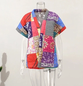Detailed close-up of colorful patchwork quilted vest featuring vibrant ethnic patterns
