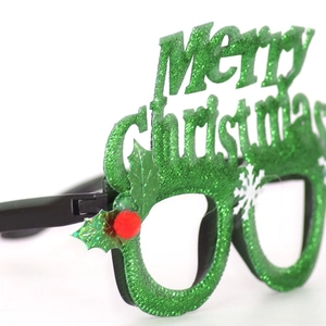 Detail of green glitter Merry Christmas glasses frame with holly leaves and red pom-poms