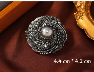 Macro detail of retro round brooch with grey pearl center and sparkling rhinestones