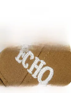 Macro detail of white 3D towel embroidery text ECHO on khaki twill baseball cap fabric