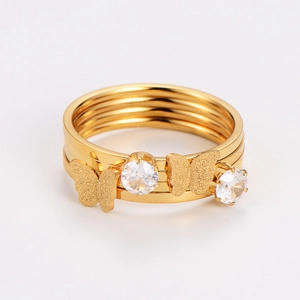 Detail of gold multi-layer ring featuring butterfly charm and sparkling zircon stones