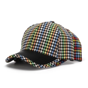 Detail of colorful houndstooth baseball cap with black leather brim and knit texture