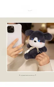 Detail of plush husky puppy with blue eyes and printed ribbon held by a person