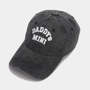 Detailed close-up of washed cotton texture and DADDY'S MINI embroidery on the cap