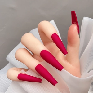 Détail de faux ongles ballerine extra longs magenta mat avec texture givrée sur modèle