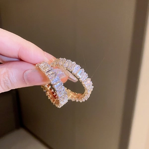 Detailed close-up of golden hoop earrings featuring square-cut sparkling cubic zirconia
