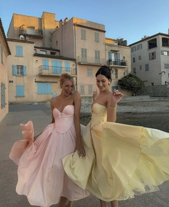 Détail de robes bustier élégantes rose et jaune avec corset sur fond de bord de mer