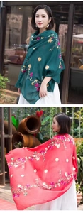 Detail of floral embroidery on deep green and bright red lightweight ethnic shawls