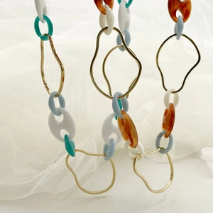 Detail of colorful acrylic links and gold metal rings on a chic chain necklace