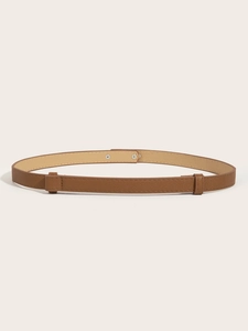 Close-up of the adjustable brown leather slim belt with high-quality metal buckle detail
