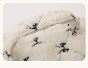 Detailed view of the fuzzy lamb wool texture and black embroidered handle on the cosmetic bag