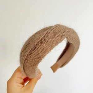 Detail of camel plush knit headband featuring a stylish crisscross knot design