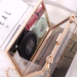 Summer clear acrylic box bag with gold chain strap and metal frame shown from a top view