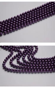 Macro view of polished deep purple round pearls with metallic luster for jewelry DIY