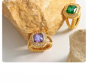 Detail of gold braided ring band with purple zircon and emerald stones and tiny crystals