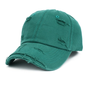 Detailed macro view of distressed dark green cotton twill baseball cap with ripped edges