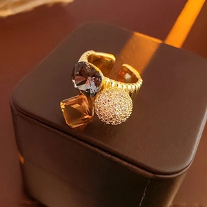 Gold plated open ring featuring amber and black crystals with micro-pave zircon ball