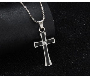 Detailed macro view of silver cross pendant with black inlay and central sparkling rhinestone