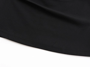 Détail macro de l'ourlet du t-shirt noir avec une finition soignée à double couture