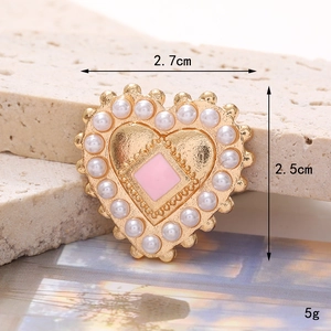 Golden heart charm with pearls and pink center on stone background, size 2.7cm x 2.5cm