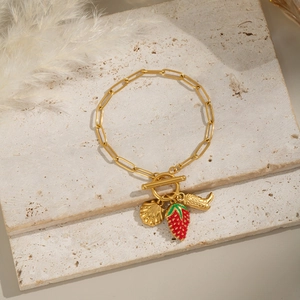 Détail du bracelet chaîne plaqué or 18K avec breloques fraise, coquillage et botte