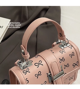 Dettaglio della borsa rosa con motivi a fiocchi neri e componenti in metallo argentato