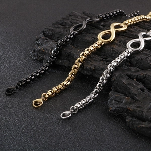 Detailansicht der Infinity-Box-Ketten in Schwarz, Gold und Silber auf dunklem Stein