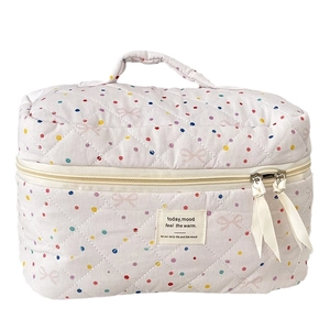 Quilted cotton cosmetic bag with pink bows and colorful polka dots featuring top handle