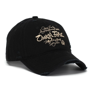 Détail macro d'une casquette vintage noire avec broderie dorée Omega Fire