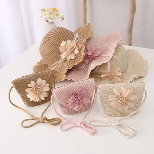 Detail of straw sun hat and matching crossbody bag with 3D floral accents for girls
