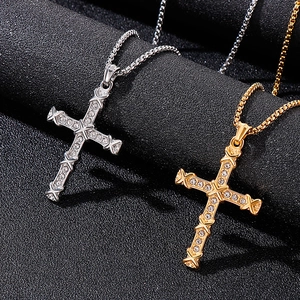 Detailed view of silver and gold iced-out cross pendants with clear crystals on box chains