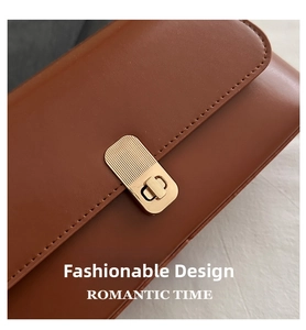 Close-up of vintage brown leather baguette bag featuring a gold rectangular twist lock